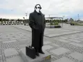 Pomnik Krzysztofa Jarzyny w Szczecinie, z charakterystyczną teczką u stóp, stoi na placu z napisem "SZCZECIN" w tle.