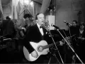 Zbigniew Kurtycz z gitarą i zespołem wykonuje swoje utwory. Wokalista w czarnym aksamitnym fraku śpiewa do mikrofonu.