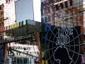 Scena Live Aid w Polsce, ozdobiona kolorowymi flagami i wielkim logo.