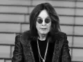 Ozzy Osbourne w okularach i błyszczącej marynarce, z naszyjnikami. Plotki o tym, że Ozzy Osbourne nie żyje, są fałszywe.