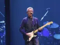 Eric Clapton gra na gitarze, wykonując swoje legendarne utwory.