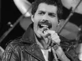 Freddie Mercury przed śmiercią, w skórzanej kurtce, śpiewa do mikrofonu. W tle widać perkusję.