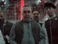Rammstein - Deutschland: mężczyźni w łańcuchach, w tle czerwone światła i ludzie na schodach.