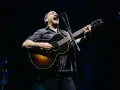 Dave Matthews z DMB śpiewa i gra na gitarze akustycznej na scenie.