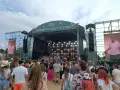 Tłum na festiwalu, na scenie OTOMOTO OLSZTYN STAGE. Kim Nowak w piasku, wśród ludzi.