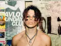 Yungblud, "The Emperor", z charakterystycznym makijażem i łańcuchami, na tle plakatów.