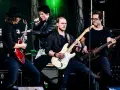 Zespół gra na scenie, wokalista śpiewa, gitarzyści i basista tworzą muzykę. Może to piosenka "Kocham Cię".