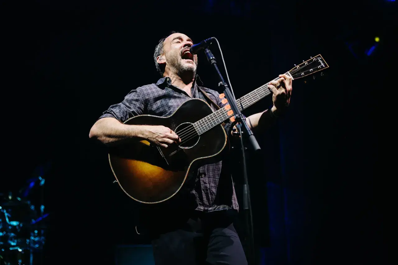 Dave Matthews z DMB śpiewa i gra na gitarze akustycznej na scenie.