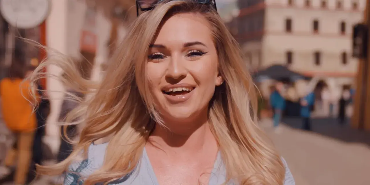 Uśmiechnięta blondynka w okularach na głowie, idealna do piosenki na 50 urodziny disco polo.