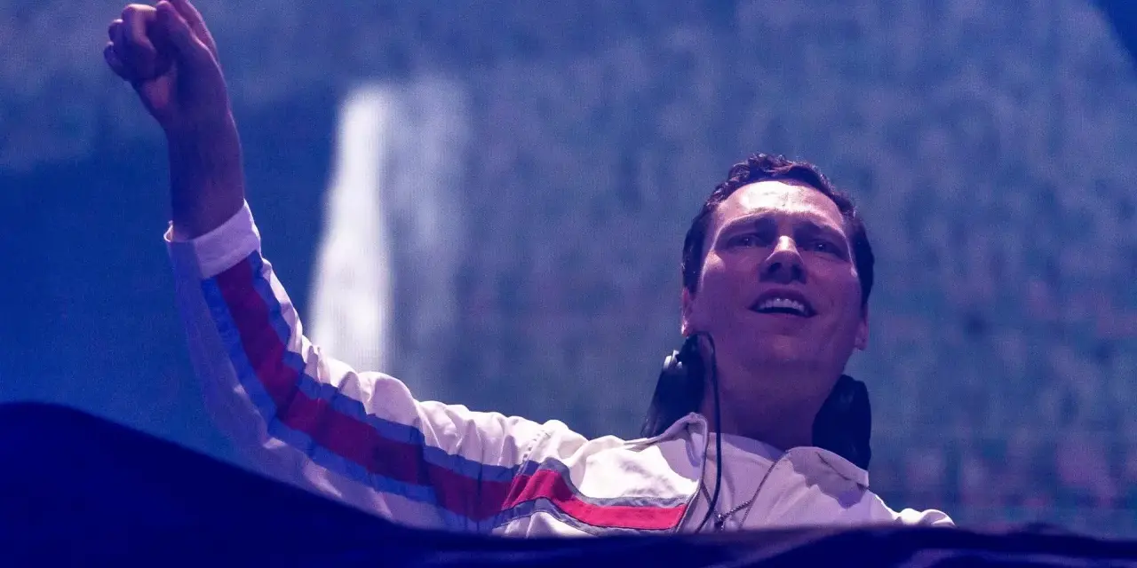 DJ Tiësto w Polsce, z palcem uniesionym w górę, wita publiczność.