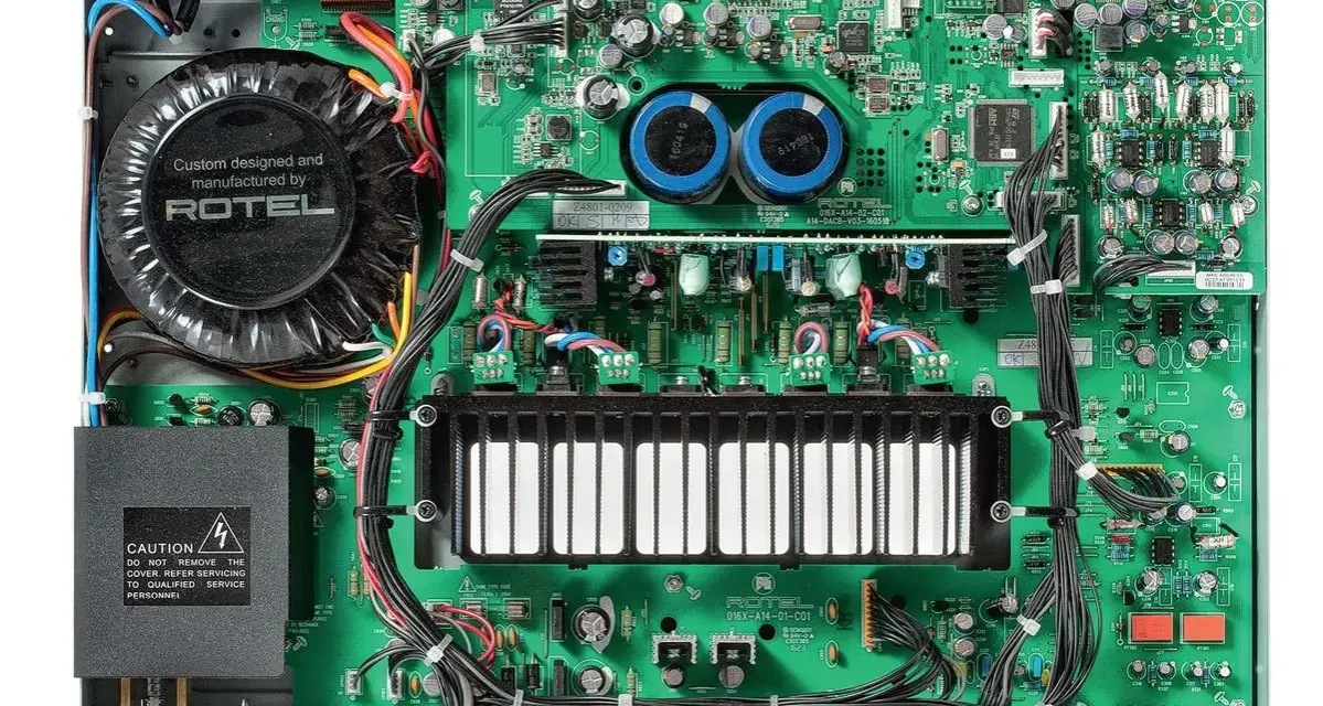 Wnętrze wzmacniacza Rotel A14 MKII z dużym transformatorem i zieloną płytką drukowaną.