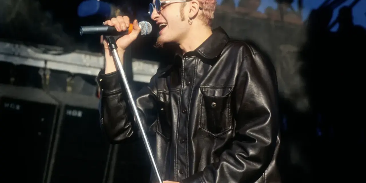Layne Staley w skórzanej kurtce śpiewa do mikrofonu. Jego śmierć wciąż porusza fanów.