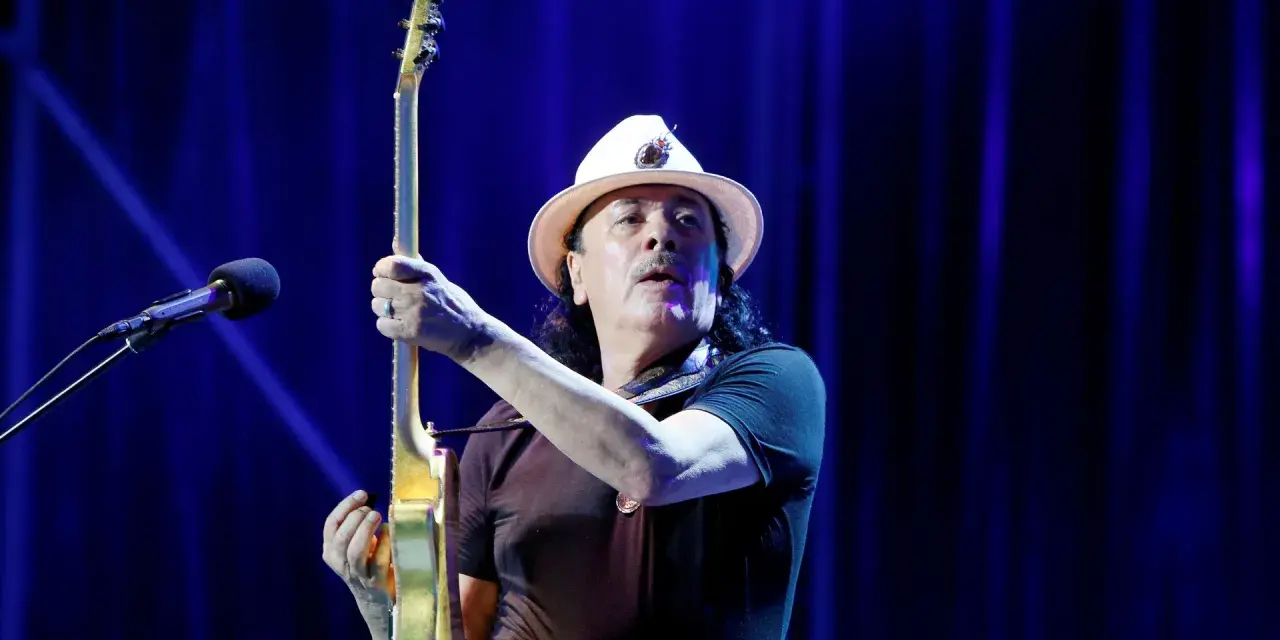 Carlos Santana z gitarą, gotowy do wykonania swoich niezapomnianych utworów.