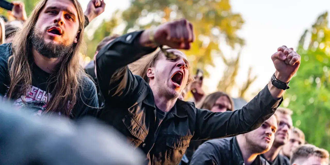 Młodzi ludzie z podniesionymi pięściami, krzyczący na koncercie. Czy to skinhead? Niekoniecznie, to po prostu fani muzyki.