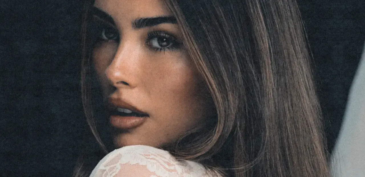 Zbliżenie na twarz Madison Beer, zmysłowe spojrzenie i delikatny uśmiech. Fani Madison Beer Polska czekają na jej powrót.