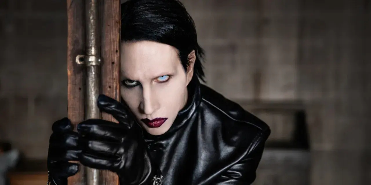 Marilyn Manson w Warszawie, w czarnej skórzanej kurtce i rękawiczkach, z charakterystycznym makijażem.