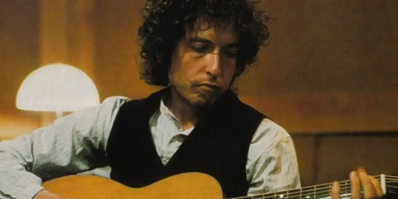Bob Dylan gra na gitarze, tworząc swoje legendarne utwory.