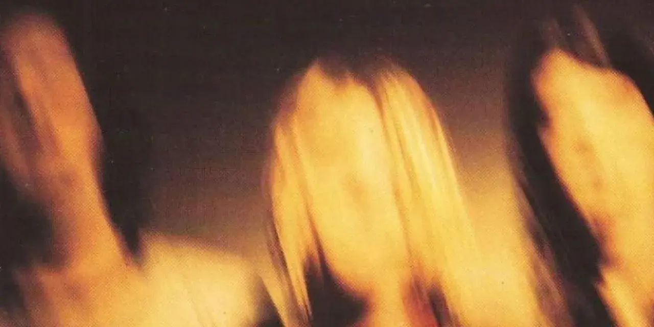 Rozmyte postacie, jakby w ruchu, z napisem "ELLS LIKE TEEN SPIR". Nirvana smells like teen spirit.
