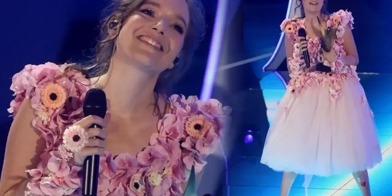 Zuzanna Jurczak, znana jako piosenkarka, w kwiecistej sukni na scenie.