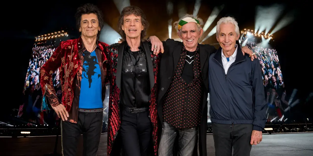 Członkowie The Rolling Stones pozują przed tłumem na jednym z ich niezapomnianych **koncertów**.