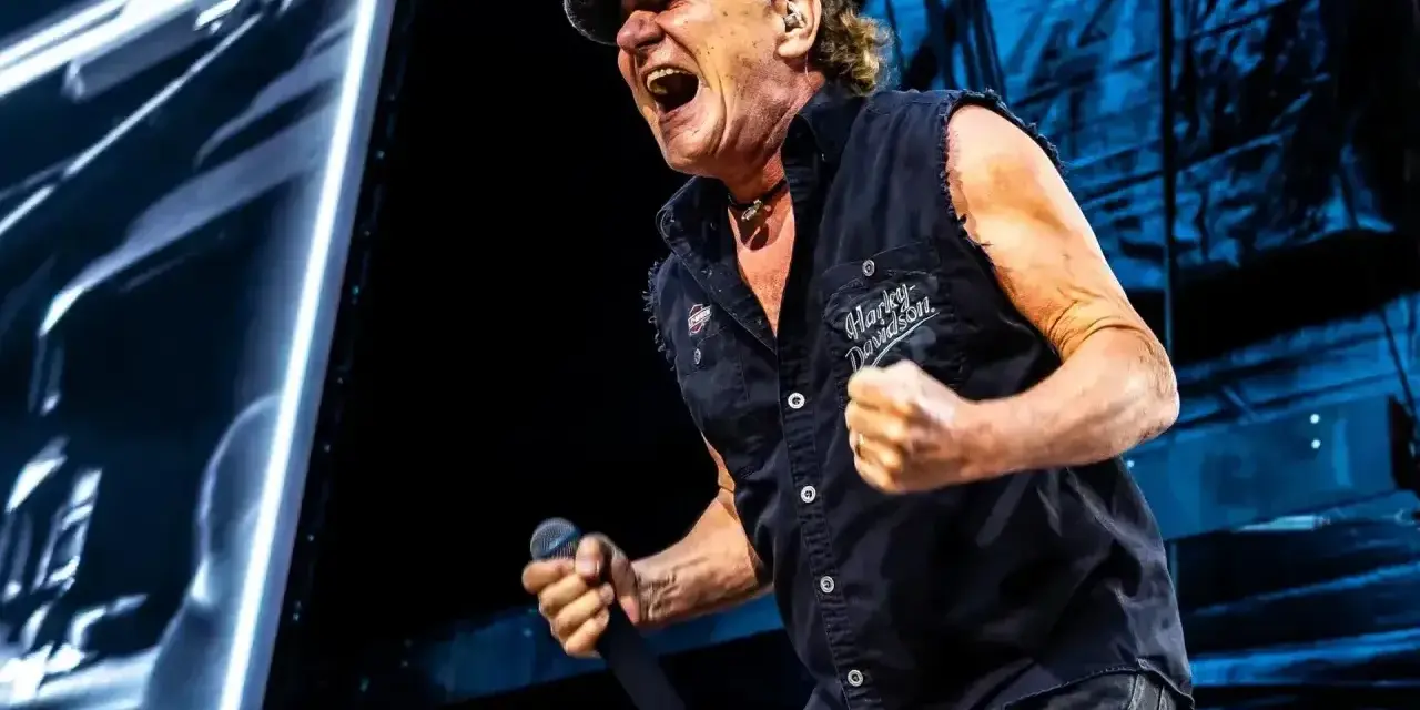 Brian Johnson z AC/DC w Polsce, w szczytowej formie, śpiewa z mikrofonem w dłoni.