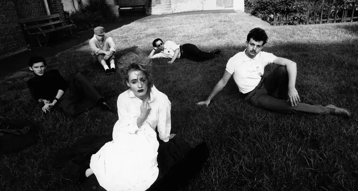Zespół Dead Can Dance na trawie, w tym Lisa Gerrard w białej sukni.