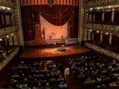 Widownia teatru z widokiem na scenę, gdzie mogą odbywać się różne rodzaje muzyki rozrywkowej.