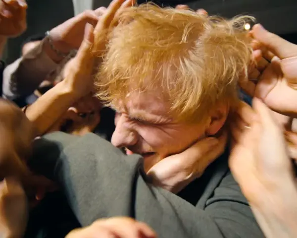 Ed Sheeran, mój azizam, otoczony przez tłum dłoni, które chcą go dotknąć.