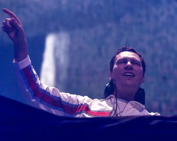 DJ Tiësto w Polsce, z palcem uniesionym w górę, wita publiczność.