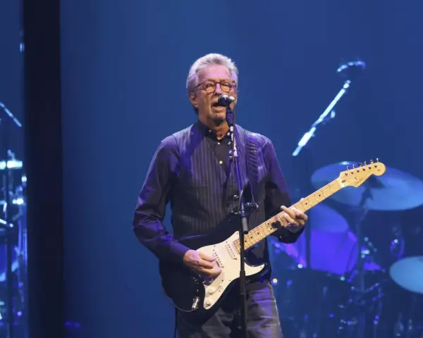 Eric Clapton gra na gitarze, wykonując swoje legendarne utwory.