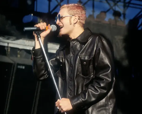 Layne Staley w skórzanej kurtce śpiewa do mikrofonu. Jego śmierć wciąż porusza fanów.
