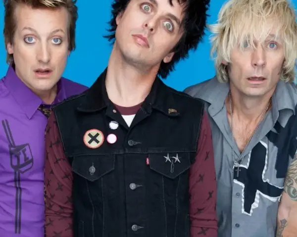 Trzech członków zespołu Green Day Polska z wyrazistymi minami na niebieskim tle.