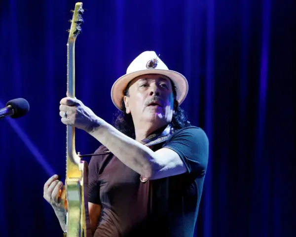 Carlos Santana z gitarą, gotowy do wykonania swoich niezapomnianych utworów.