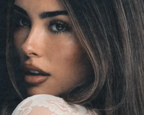 Zbliżenie na twarz Madison Beer, zmysłowe spojrzenie i delikatny uśmiech. Fani Madison Beer Polska czekają na jej powrót.