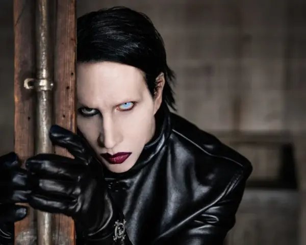 Marilyn Manson w Warszawie, w czarnej skórzanej kurtce i rękawiczkach, z charakterystycznym makijażem.