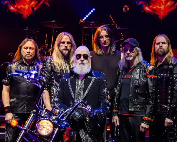 Judas Priest Polska: zespół w skórzanych kurtkach z ćwiekami, z motocyklem na scenie.