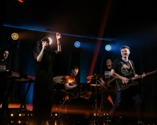 Zespół rockowy na scenie: wokalistka, gitarzysta, basista, perkusista i klawiszowiec. Koncert jak z listy zespoły rockowe zagraniczne alfabetycznie.