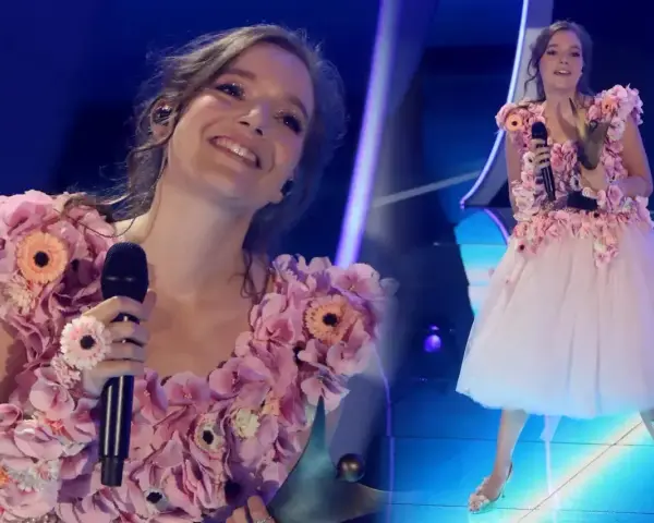 Zuzanna Jurczak, znana jako piosenkarka, w kwiecistej sukni na scenie.