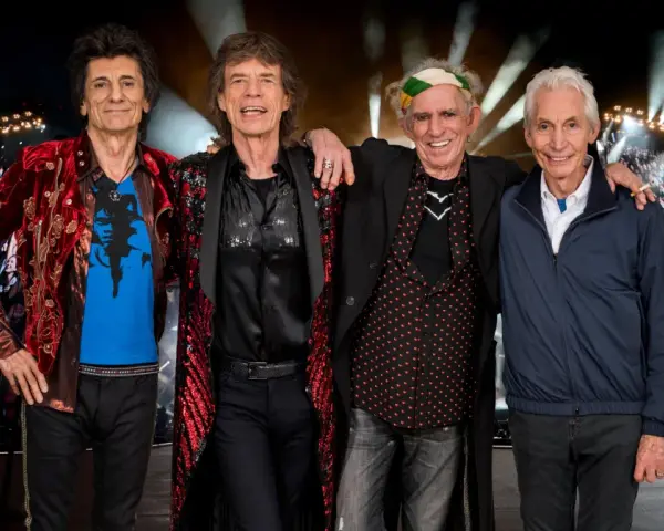 Członkowie The Rolling Stones pozują przed tłumem na jednym z ich niezapomnianych **koncertów**.