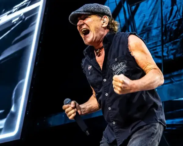 Brian Johnson z AC/DC w Polsce, w szczytowej formie, śpiewa z mikrofonem w dłoni.