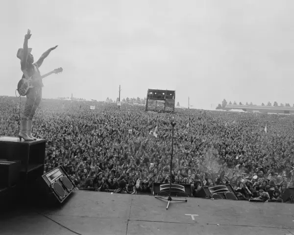 Ogromny tłum na koncercie Metallica Moskwa 1991. Wokalista na scenie, ręce w górze, wita fanów.