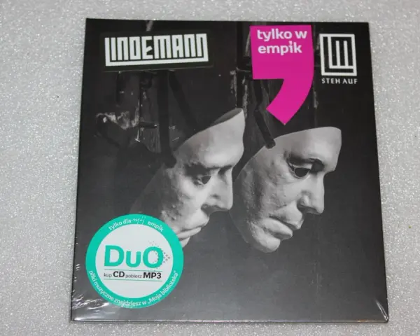 Okładka płyty Lindemann "Steh Auf" z dwoma maskami. "Tylko w Empiku" i "Duo" na zielonej naklejce.
