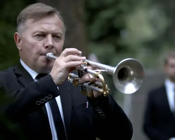 Mężczyzna w garniturze gra na trąbce. To jego ulubiona piosenka na pogrzebie, która wzrusza zgromadzonych.