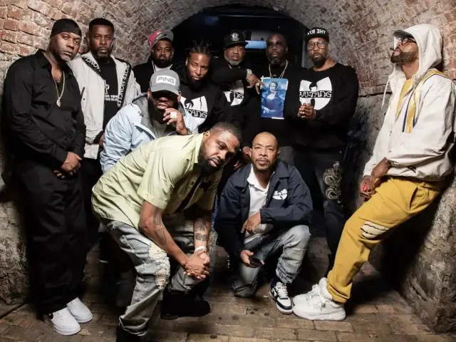 Grupa Wu-Tang Clan członkowie pozuje w tunelu. Wszyscy ubrani w charakterystyczne bluzy z logo.