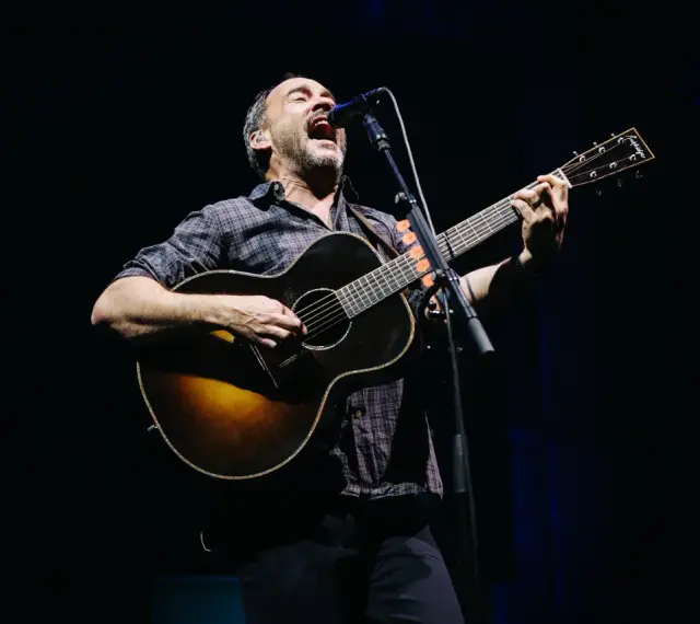 Dave Matthews z DMB śpiewa i gra na gitarze akustycznej na scenie.