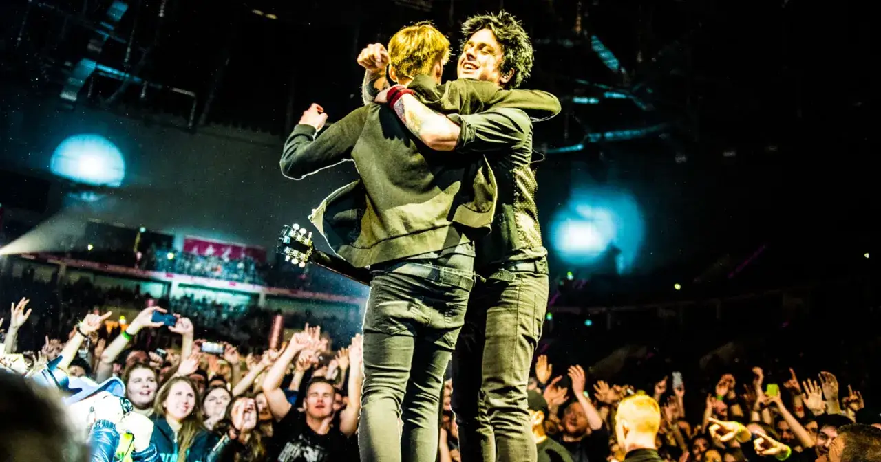 Billie Joe Armstrong i Mike Dirnt z Green Day Polska w uścisku na scenie, tłum szaleje.