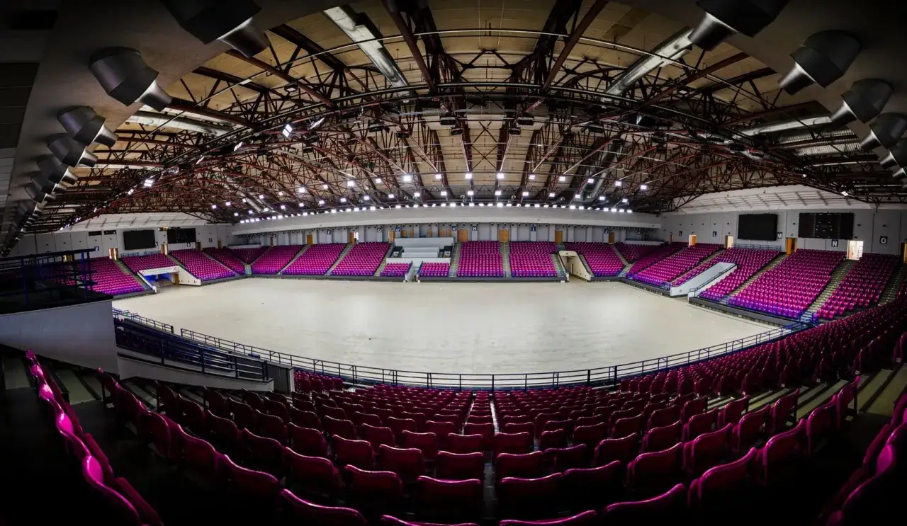 Pusta arena COS Torwar z rzędami fioletowych krzesełek, gotowa na zawody lub koncert.