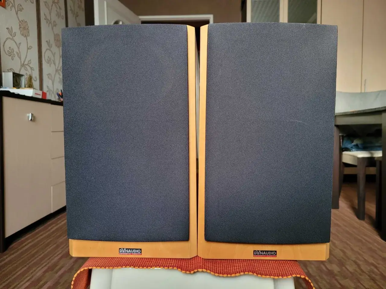 Para głośników Dynaudio Focus 140 z czarnymi maskownicami i drewnianą ramką.