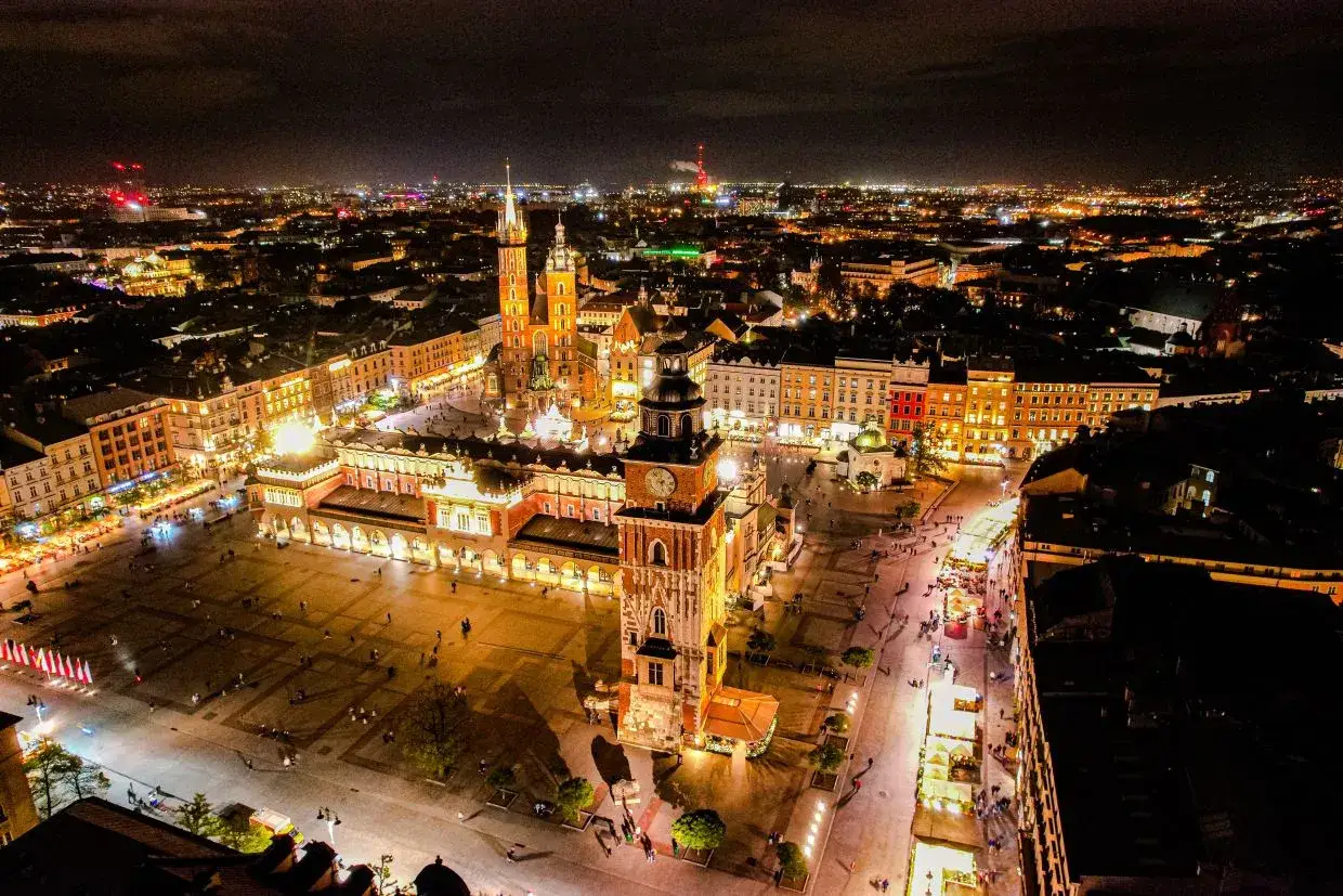 Nocny Rynek Główny w Krakowie, jak z piosenki o Krakowie. Sukiennice i Kościół Mariacki oświetlone, tworzą magiczny klimat.