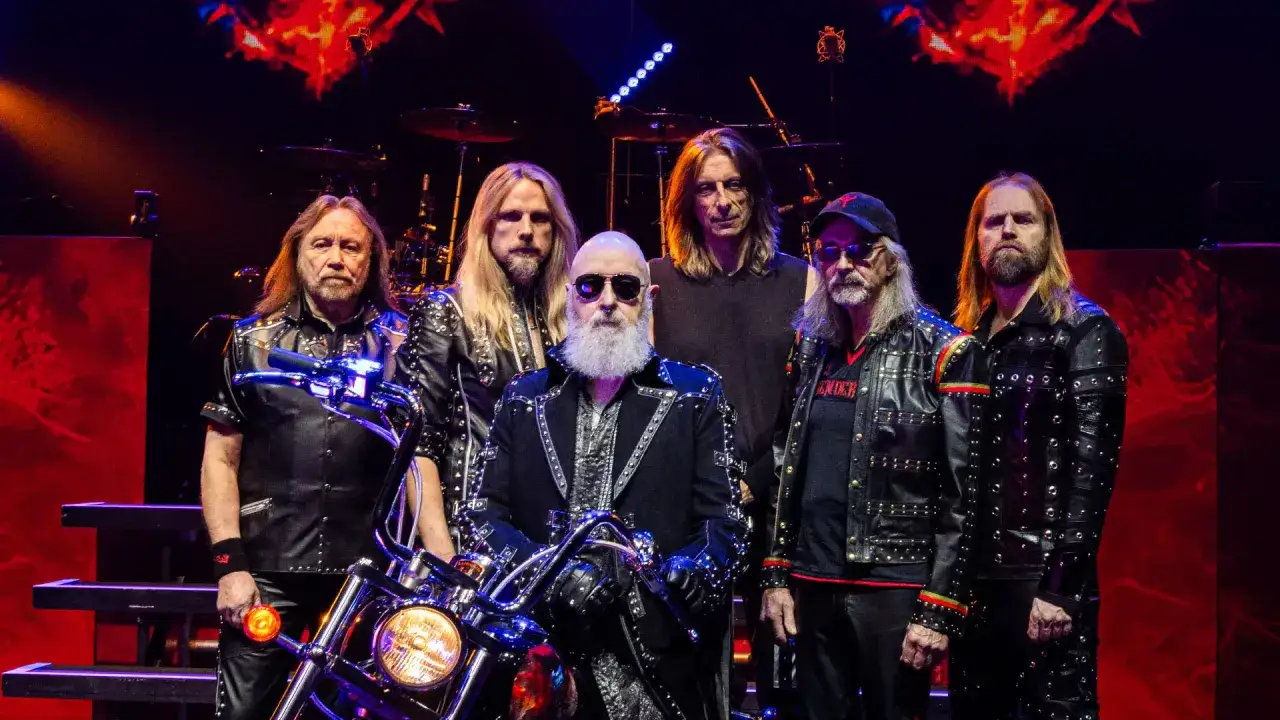 Judas Priest Polska: zespół w skórzanych kurtkach z ćwiekami, z motocyklem na scenie.